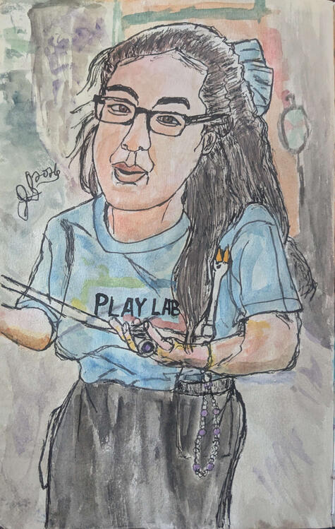 An Asian-American Pokemon Play Lab ambassador holds a blowing instrument with a goose at the end of it.